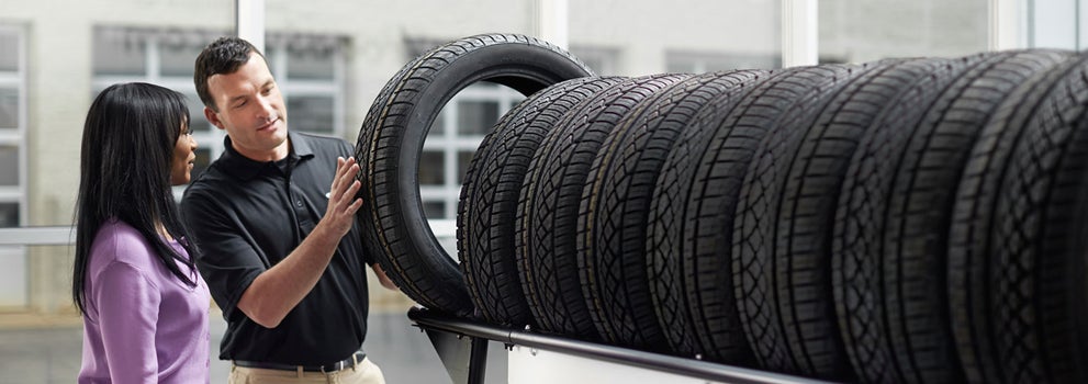Subaru service representative showing customer a tire. | Vann York Subaru in Asheboro NC